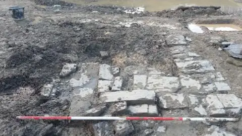 WWHA Post-medieval stone building partially excavated, view to west. 2m scale 