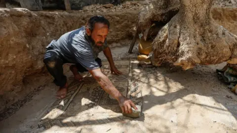 Reuters Salman al-Nabahin cleaning the mosaic floor discovered on his farm in Gaza