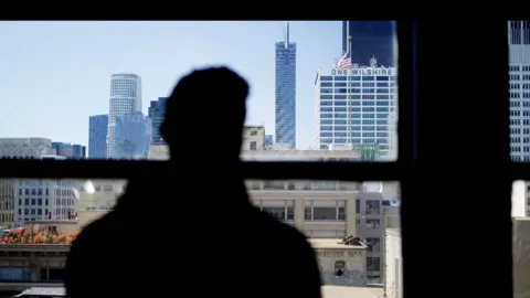 Luke, pictured successful  silhouette, looking astatine  the skyline successful  Los Angeles