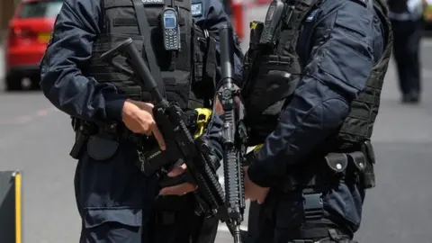 Getty Images Armed police stand guard near London Bridge station following an attack in the capital, 4 June 2017