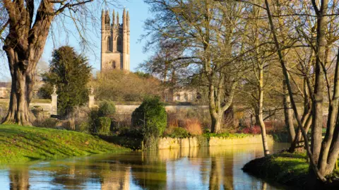 Planet One Images Magdalen Tower in Oxford, viewed from the banks of the Cherwell in winter. 