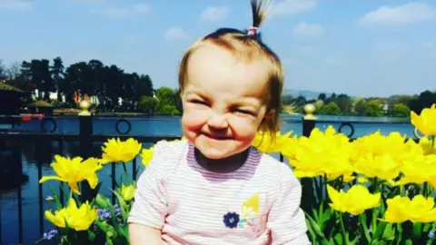 Family photo Kiara surrounded by daffodils in full flower