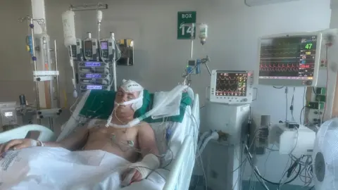 PA Media Undated family handout photo of Dan Hurst in hospital after the incident. The teenager has described how a serious head injury sustained while on a football holiday in Ibiza left him on a stroke ward for four months.
