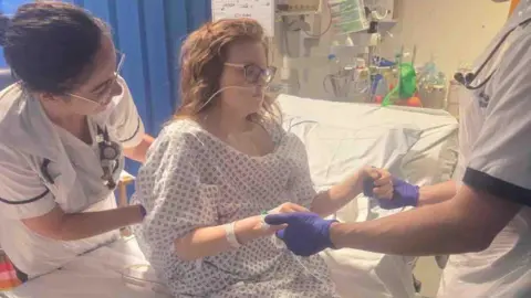 Natalie-Anne Rowlett Felicity-Jo sits up for the first time in three weeks in a hospital bed.