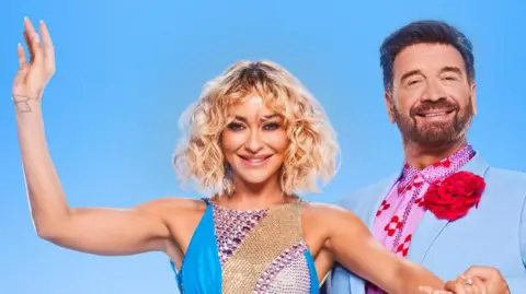 BBC/PA Nick Knowles with his dance partner Luba Mushtuk, both are wearing blue and are dressed for a performance on the show