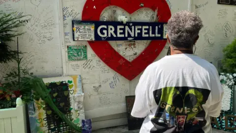 BBC A woman looks at wall of tributes to Grenfell victims 