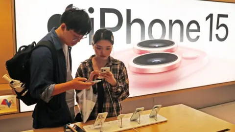 Getty Images Customers try iPhone 15 at Apple store in Shanghai, China.