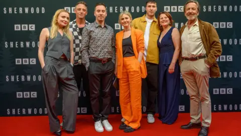 Foto do folheto da PA Media BBC dos membros do elenco da segunda temporada de Sherwood (da esquerda para a direita): Christine Bottomley, Perry Fitzpatrick, James Graham (escritor), Ria Zmitrowicz, Oliver Huntingdon, Monia Dolan e Robert Lindsay.