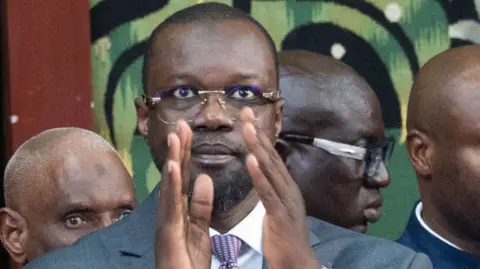 Ousmane Sonko applauds his supporters in parliament on Tuesday.