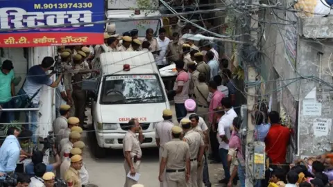 AFP Indian policemen carry the body of a victim into a hearse van after 11 family members were found dead inside their home in the neighbourhood of Burari in New Delhi on July 1, 2018.