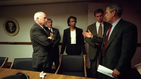 George W. Bush Presidential Library/Getty Images Cheney, Condoleezza Rice and George W Bush, as well as two other men, speaking in a board room