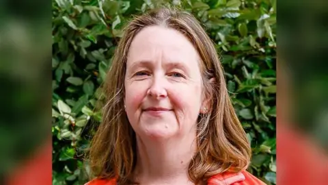 Lewes District Council A woman with shoulder-length brown hair looking and smiling at the camera