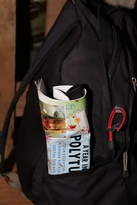 CPS A black backpack, with a flyer poking out of a pocket. 
