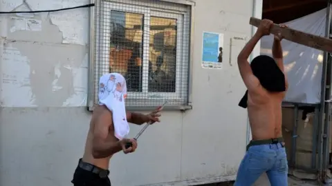 EPA Refugees attack a housing facility at the Moria camp. Photo: 29 September 2019