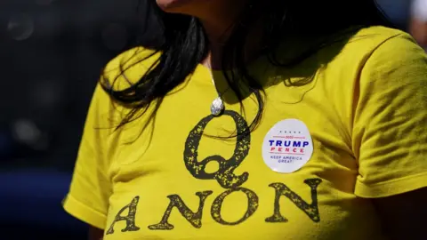 Reuters A supporter of US President Donald Trump wears a QAnon shirt after participating in a caravan convoy circuit in Adairsville, Georgia, 5 September 2020