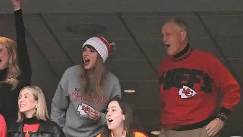 Getty Images Taylor Swift, and Scott Swift cheer while watching the game between the Kansas City Chiefs and New England Patriots at Gillette Stadium on December 17, 2023 in Foxboro, Massachusetts.