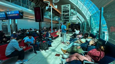 Getty Images Passengers wait for their flights at the Dubai International Airport in Dubai