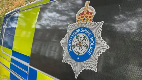 BBC/Seb Cheer A North Yorkshire Police logo on the side of a police van.