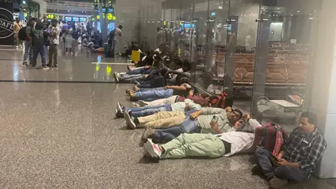 Stranded passengers in Doha sitting and lying on the floor