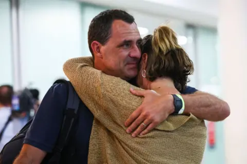 A couple embrace at Brisbane airport