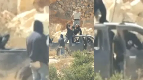 Israeli settlers stood on top of a pickup truck