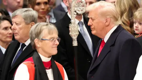 Right Rev. Mariann Edgar Budde walking past President Trump