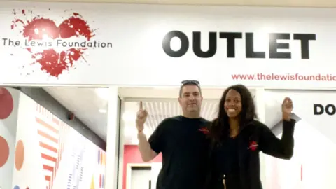 The Lewis Foundation Founders of The Lewis Foundation in front of the outlet shop