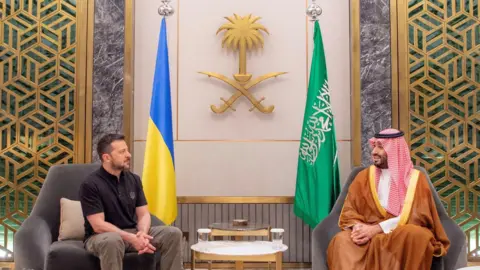 Presiden Ukrania Reuters Volodymyr Zelensky dan Putra Mahkota Saudi Mohammed bin Salman duduk di kursi -kursi di seberang satu sama lain 