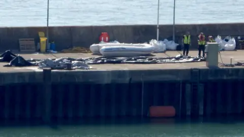PA Media A deflated dinghy is seen on the quayside in Dover, Kent. A record 230 migrants arrived after crossing the Channel to the UK in a single boat on Monday
