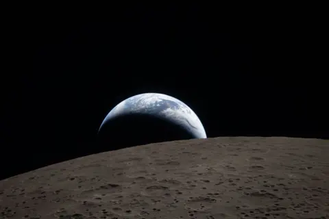NASA Image of Earthrise poking out over the surface of the moon