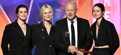 Getty Images Inga Ibsdotter Lilleaas, Elle Fanning, Stellan Skarsgård, and Renate Reinsve accept Best Intergen/Foreign for Sentimental Value onstage during the 2026 Annual Movies for Grownups Awards with AARP in Los Angeles. They are all wearing black.