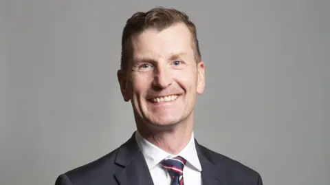 UK Parliament/PA Dave Doogan has short brown hair and wears a dark suit and white shirt