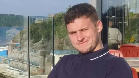 Leeds United fan Ed O'Brien sat down holding a glass.
