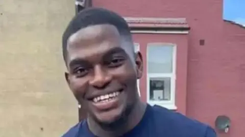 PA Media A file image of Chris Kaba, a young man with short dark hair wearing a dark blue t-shirt