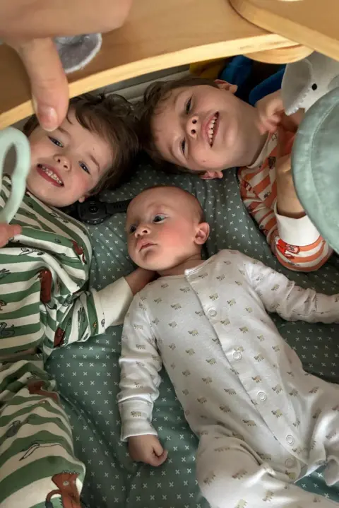 Family Photo Big brothers huddle around a baby