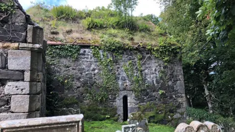An old stone walled church with walls covered by ivy