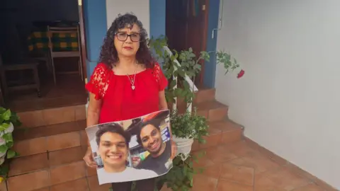 Rosario Magaña takes a picture of her two sons