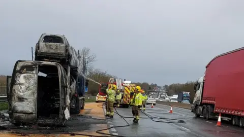 Staffordshire Fire A burnt-out van and transporter on the M6