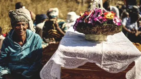 Getty Images The mother of Ishmael Kumire, 42, sits next to her son's coffin during his funeral ceremony after he was shot during post-election violence on August 1 in Harare, at his homestead in Chinamhora village, Domboshava, outside Harare, on August 4, 2018
