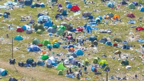 Big Ladder Photographer Close up, taken by a drone, of Reading Festival aftermath of green and blue tents and plastic and paper rubbish left behind by festival-goers.