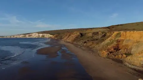 The cliffs along Compton Bay above a sandy beach.