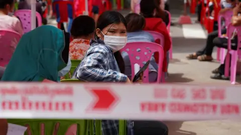 Reuters People wait to get tested inside a red zone with strict lockdown measures during the latest outbreak of the coronavirus disease (COVID-19) in Phnom Penh, Cambodia