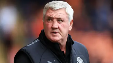 Steve Bruce, who has grey hair, on the touchline at a Blackpool match wearing a black gilet with the club crest over a dark long-sleeved top.