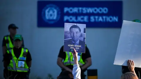 Finnbarr Webster/Getty Images Henry Nowak portrait held up in front of Portswood police station.