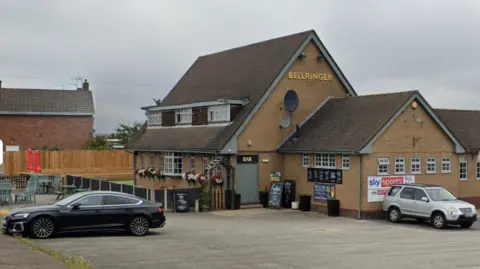Google The view from the car park of the Bellringer pub. A brick building with the words "Bellringer" written in gold lettering. Cars can be seen parked in front.