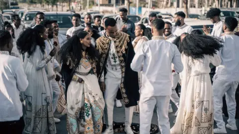 AMANUEL SILESHI Couples who are getting married dance in the street in the streets of Mekelle, Ethiopia, on May 26, 2024.