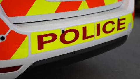 The back of a police car with orange and yellow stickers