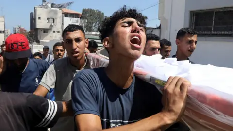 Mourners react during the funeral of Palestinians reportedly killed in an Israeli air strike, at al-Shifa hospital, in Gaza City (25 June 2025)