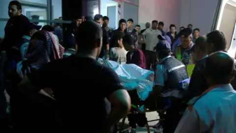 Reuters Injured person at hospital as relatives of victims wait