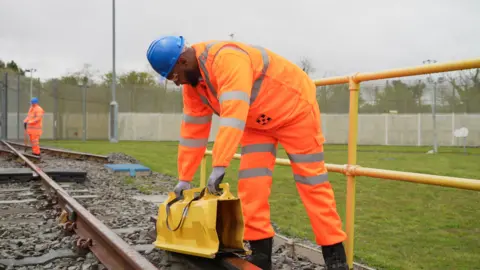 Zoie O'Brien/BBC Othman working on the railway track 